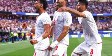 Calciatori dell'Iran in maglia bianca festeggiano con entusiasmo durante la partita dei Mondiali 2026