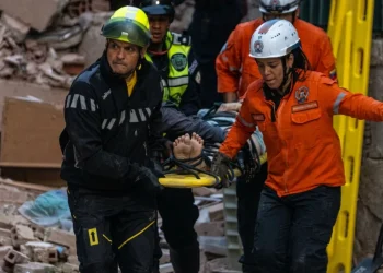 Soccorritori trasportano vittima su barella dopo terremoto a Caracas in Venezuela