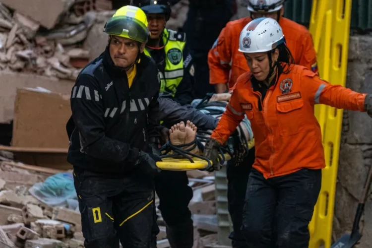 Soccorritori trasportano vittima su barella dopo terremoto a Caracas