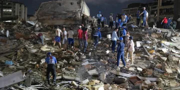 Vigili del fuoco venezuelani cercano sopravvissuti tra le macerie di un edificio crollato