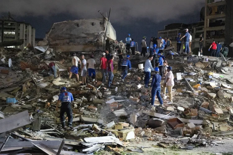 Vigili del fuoco venezuelani cercano sopravvissuti tra le macerie di un edificio crollato