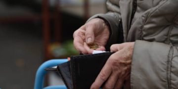 uomo seduto con portafoglio in mano