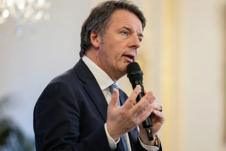 Matteo Renzi parla al microfono con un abito blu.