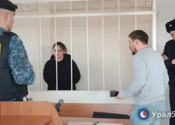 Donne e uomini in gabbia in aula di tribunale in Russia.