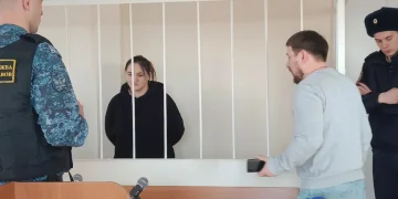 Donne e uomini in gabbia in aula di tribunale in Russia.