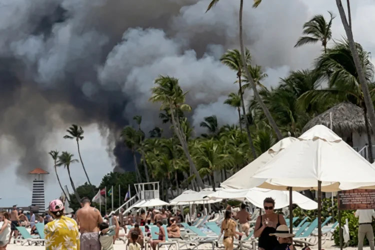 Fumo nero da un incendio su una spiaggia caraibica affollata