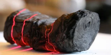 Rotolo carbonizzato di Ercolano illuminato da linee laser rosse per scansione.