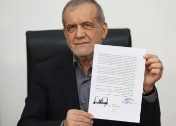 Uomo di mezza età trattiene firma autografo su foglio