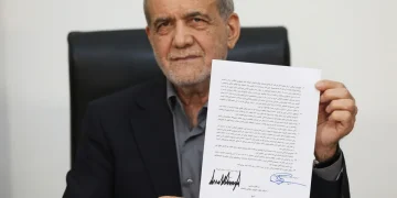 Uomo di mezza età trattiene firma autografo su foglio