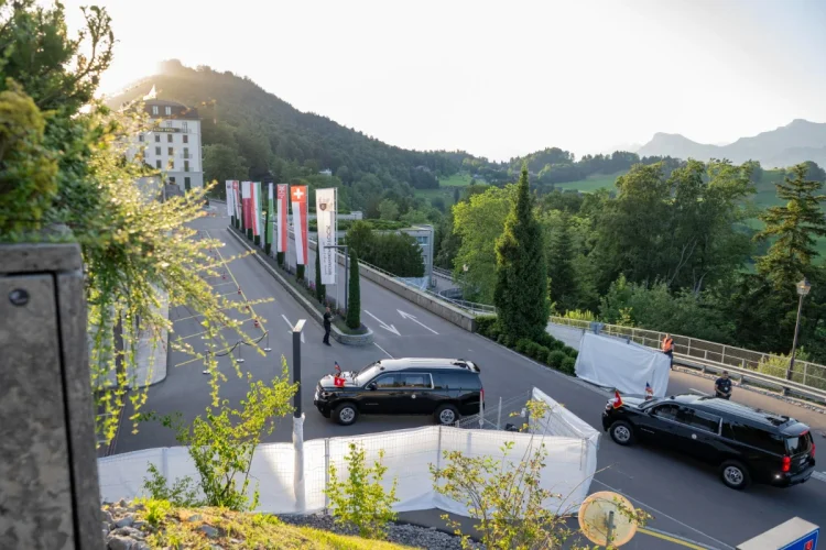 SUV nero con bandiere sventolanti vicino hotel in Svizzera