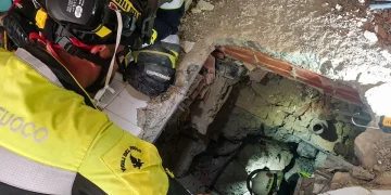 Vigile del fuoco italiano scava tra macerie con una torcia