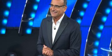 Primo piano di Carlo Conti sorridente, conduttore e direttore artistico di Tale e Quale Show su Rai 1.