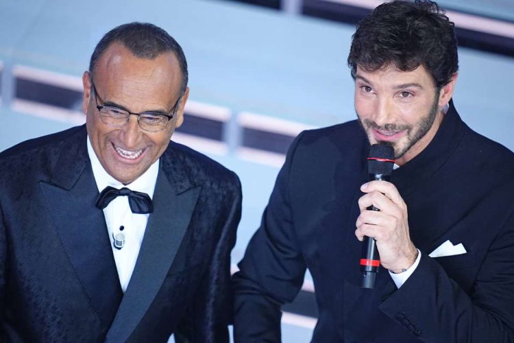 Stefano De Martino e Carlo Conti sorridenti sul palco del Festival di Sanremo