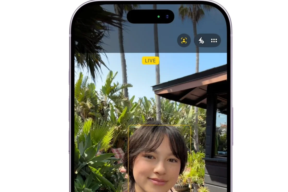 iPhone mostra interfaccia fotocamera con ragazza sorridente, sfondo verde