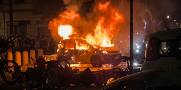 Auto in fiamme sulla strada di Bologna di notte. Morte Abderrahim Fakir, un'auto del Comune incendiata durante gli scontri