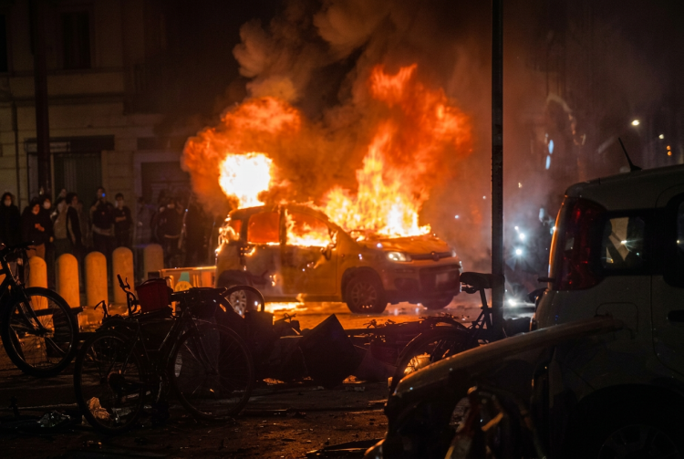 Auto in fiamme sulla strada di Bologna di notte. Morte Abderrahim Fakir, un'auto del Comune incendiata durante gli scontri