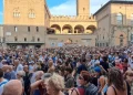 Folla numerosa riempie Piazza Maggiore a Bologna durante presidio.