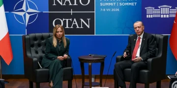 Giorgia Meloni e Recep Tayyip Erdoğan seduti a un tavolo NATO.
