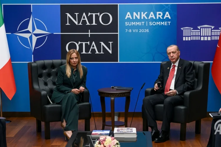 Giorgia Meloni e Recep Tayyip Erdoğan seduti a un tavolo NATO.