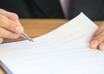Mano di persona che firma documenti con penna stilografica
