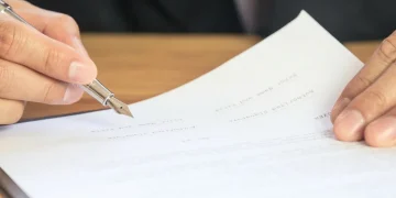 Mano di persona che firma documenti con penna stilografica