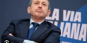 Andrea Delmastro Delle Vedove in completo scuro e cravatta blu