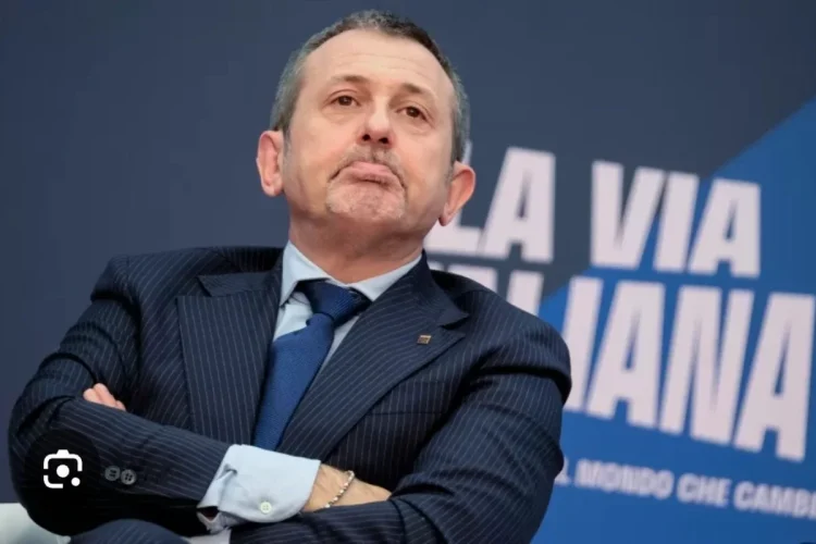 Andrea Delmastro Delle Vedove in completo scuro e cravatta blu