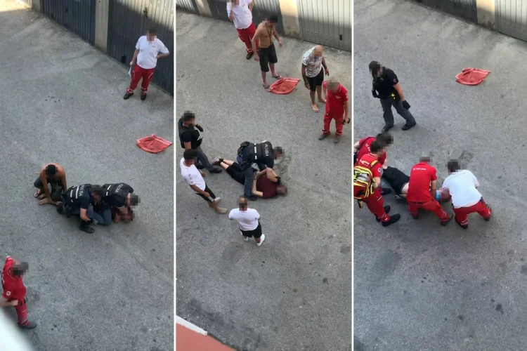 Poliziotti e soccorritori assistono un uomo disteso a terra