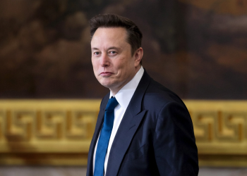 Elon Musk in completo scuro e cravatta blu guarda l'obiettivo. Musk attacca giudice e pm sul caso Roggero: "Sentenza folle, meritano la condanna"