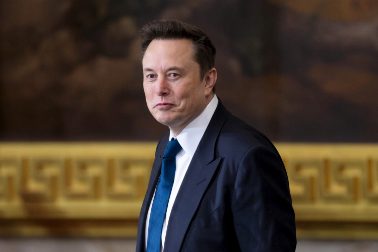 Elon Musk in completo scuro e cravatta blu guarda l'obiettivo. Musk attacca giudice e pm sul caso Roggero: "Sentenza folle, meritano la condanna"