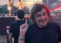 Claudio Cecchetto sorride indica, dietro giovani in boxer bianchi su palco