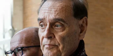Clemente Mastella in primo piano col volto leggermente corrucciato parla del tumore