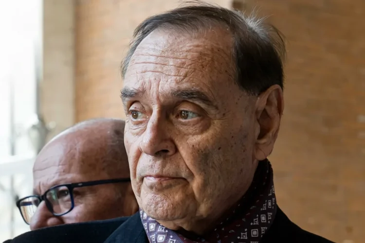 Clemente Mastella in primo piano col volto leggermente corrucciato parla del tumore