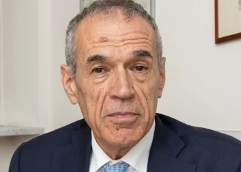 Carlo Cottarelli in primo piano con giacca blu e cravatta