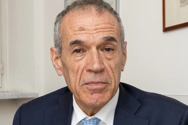 Carlo Cottarelli in primo piano con giacca blu e cravatta