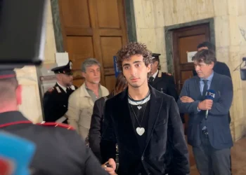 Davide Cavallo in tribunale con Carabinieri e giornalisti, sguardo serio