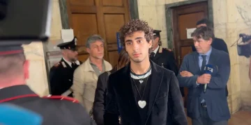 Davide Cavallo in tribunale con Carabinieri e giornalisti, sguardo serio