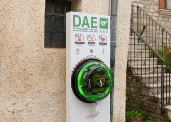 Defibrillatore pubblico DAE verde installato su muro esterno