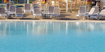 Piscina azzurra con sdraio e ombrelloni gialli a Sestri Levante