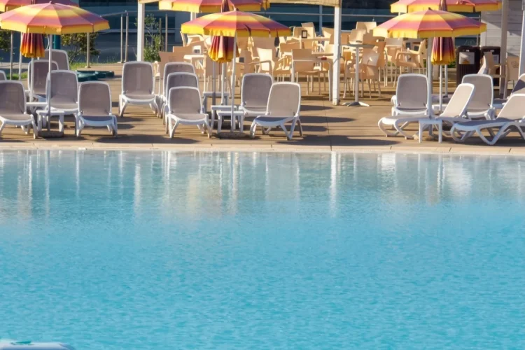 Piscina azzurra con sdraio e ombrelloni gialli a Sestri Levante