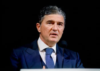 Enrico Pazzali parla al microfono con giacca e cravatta blu.