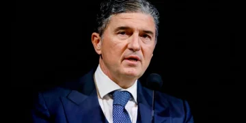 Enrico Pazzali parla al microfono con giacca e cravatta blu.