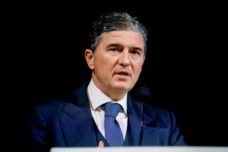 Enrico Pazzali parla al microfono con giacca e cravatta blu.
