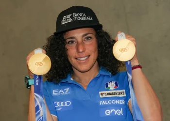 Sciatrice Federica Brignone sorride mostrando due medaglie olimpiche d'oro.