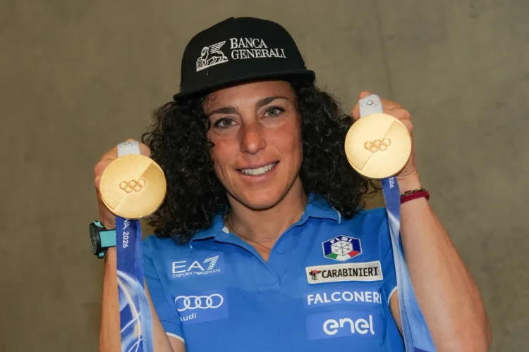 Sciatrice Federica Brignone sorride mostrando due medaglie olimpiche d'oro.