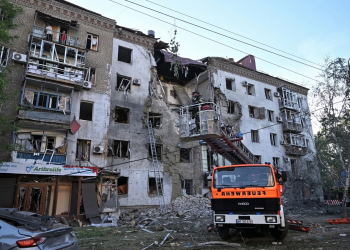 Vigile del fuoco su cestello ispeziona edificio residenziale gravemente danneggiato. Fmi sblocca 690 milioni di dollari per il sostegno all’Ucraina nella guerra contro la Russia