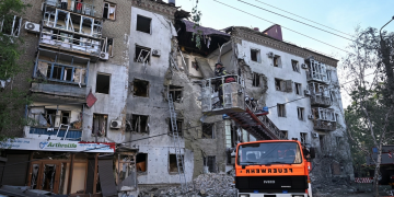 Vigile del fuoco su cestello ispeziona edificio residenziale gravemente danneggiato. Fmi sblocca 690 milioni di dollari per il sostegno all’Ucraina nella guerra contro la Russia