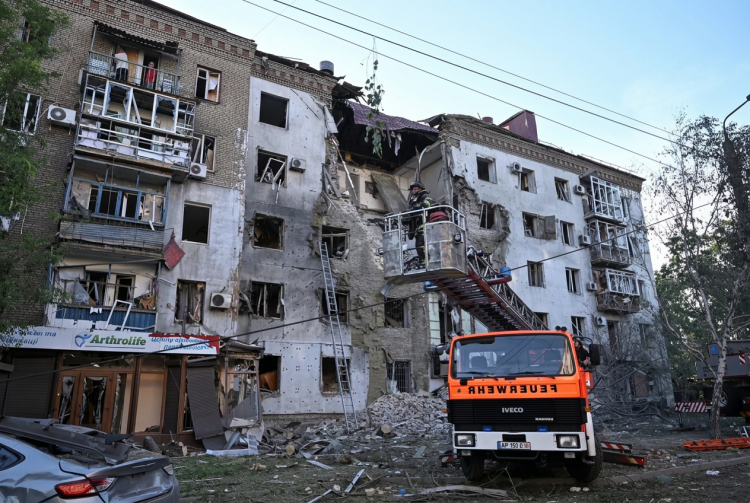 Vigile del fuoco su cestello ispeziona edificio residenziale gravemente danneggiato. Fmi sblocca 690 milioni di dollari per il sostegno all’Ucraina nella guerra contro la Russia