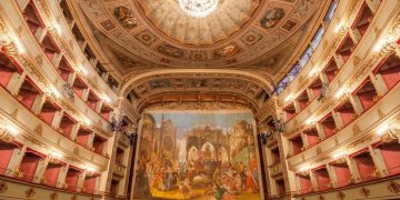 Maestoso teatro storico italiano con palchi dorati e affresco sul fondale. I teatri condominiali italiani entrano nel Patrimonio Unesco: salgono a 62 i siti nel nostro Paese