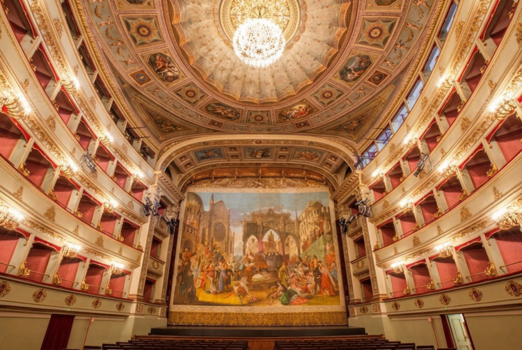 Maestoso teatro storico italiano con palchi dorati e affresco sul fondale. I teatri condominiali italiani entrano nel Patrimonio Unesco: salgono a 62 i siti nel nostro Paese